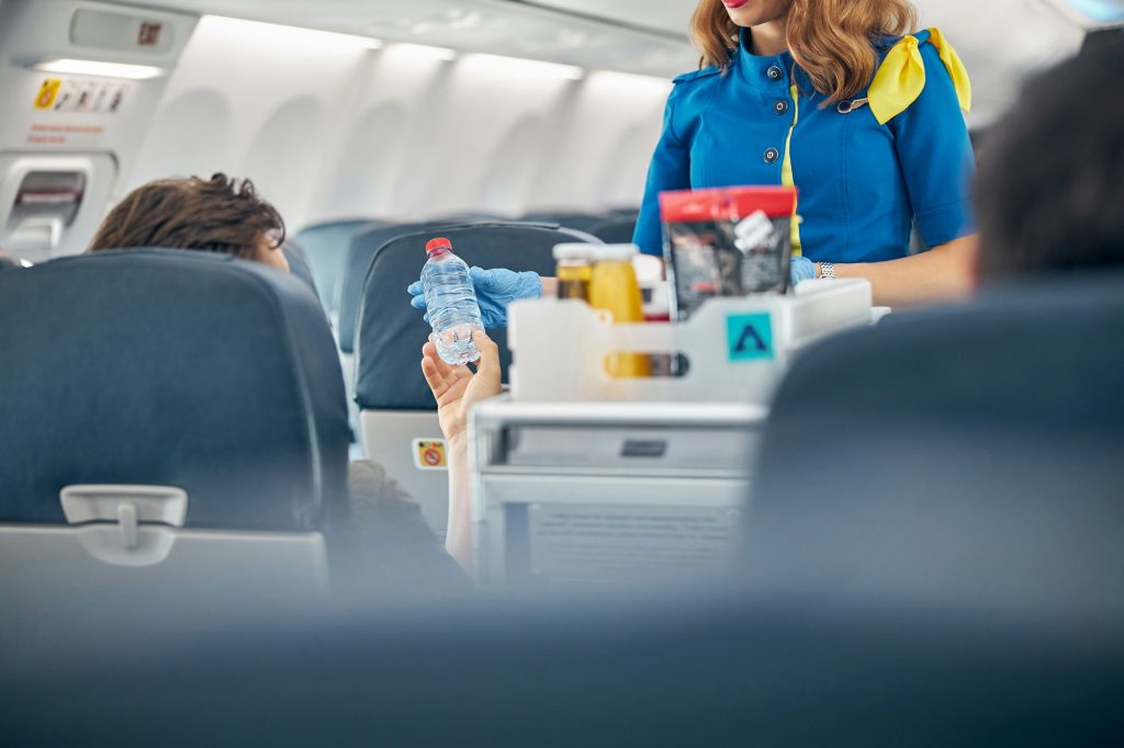 Air stewardess serving snacks from the drinks trolley