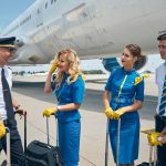 Cheerful airline workers chatting at airport before the flight