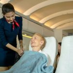 Flight attendant fastening blanket to passenger in planes,Airline transportation and tourism.